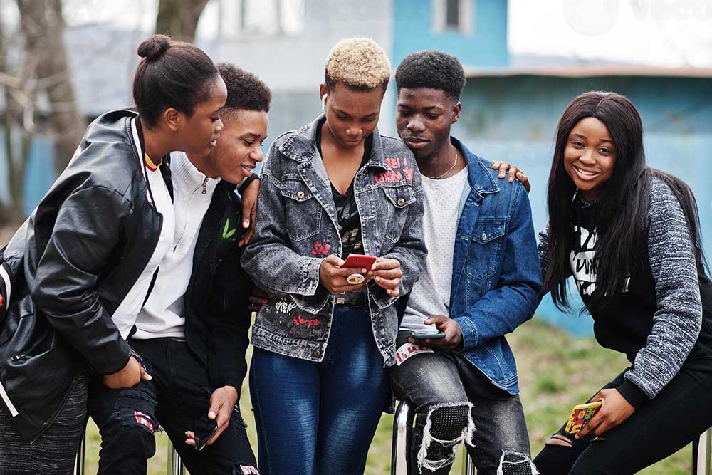 Photo of young people using a phone.